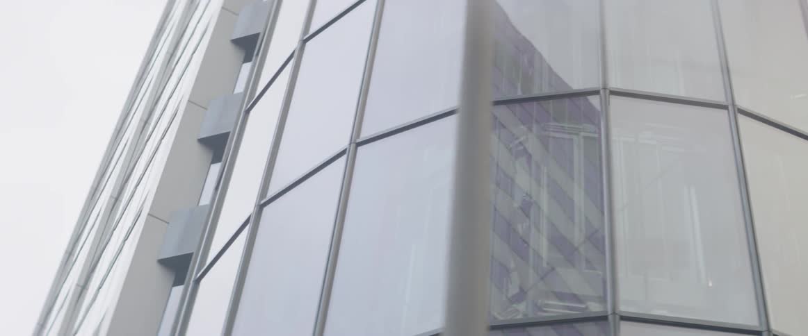 The windows of a building reflect the surrounding skyscrapers