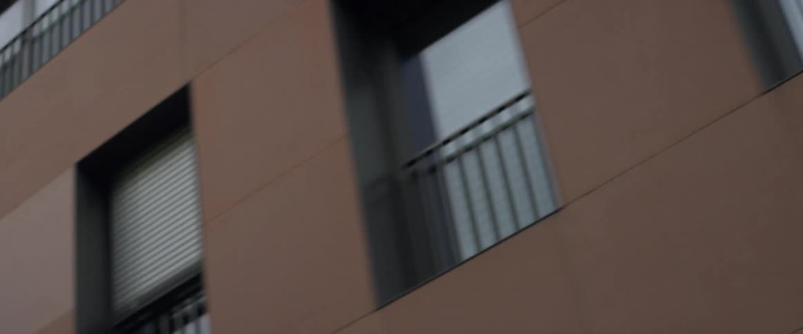 Passing by a large brown building in a city