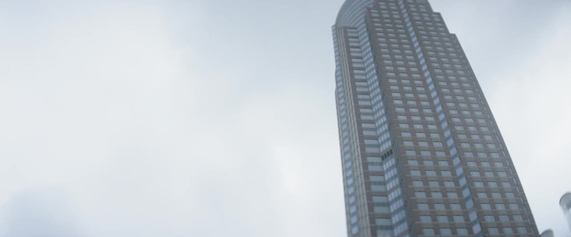 A tall glass skyscraper towers into the sky