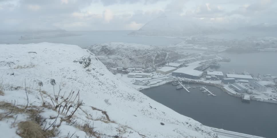 The tall hills around the port town are covered with snow