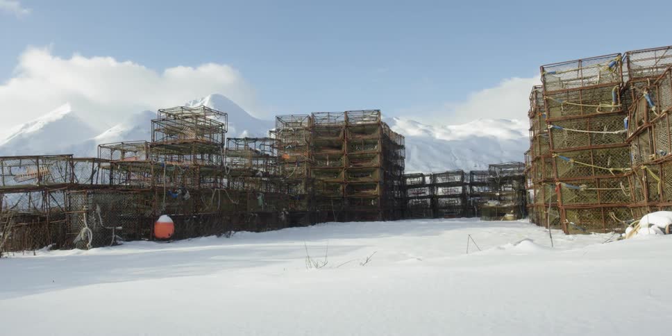 The snowy field is lined with crab pots