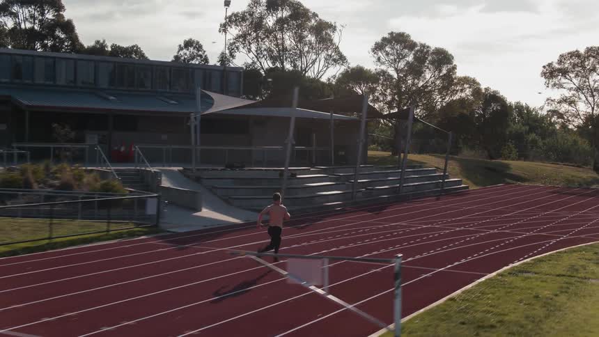 A man is running on a track during the day