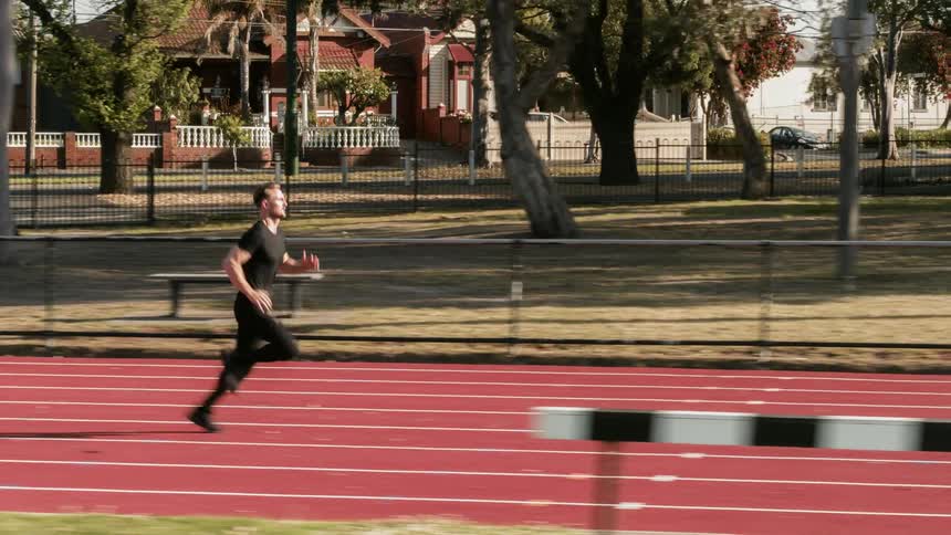 A man runs on an outdoor track