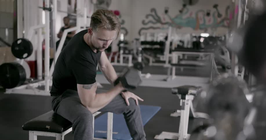 A man lifts weights in a gym