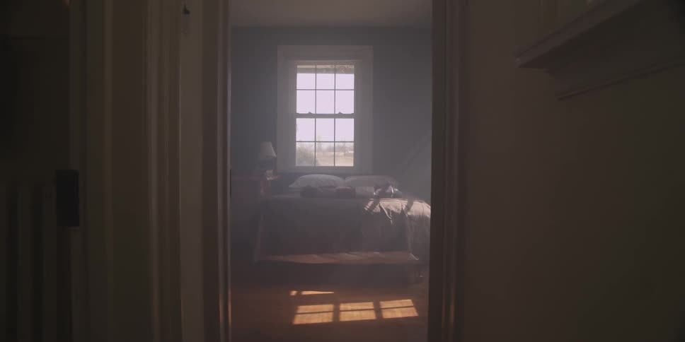 Hallway and doorway leads to a bedroom with a window and sunlight shining through