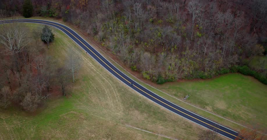 A person rides their motorcycle on the long road
