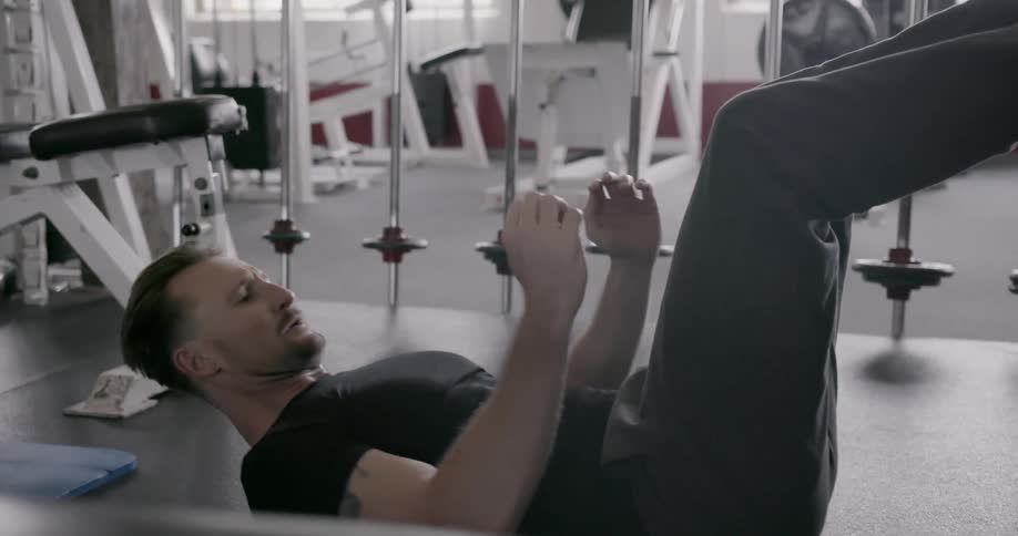 A man does sit ups in a gym