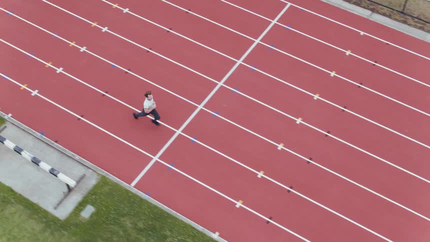 A man runs outside on a running track