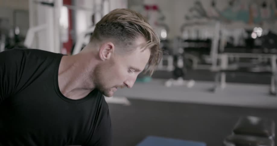 A man lifts weights in a gym