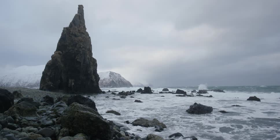 The waves crash against a rocky shore