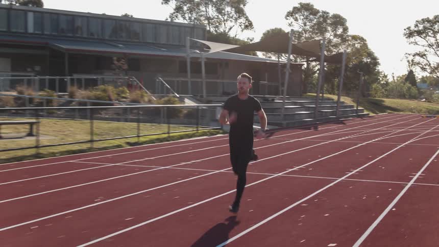 A man runs on an outdoor track