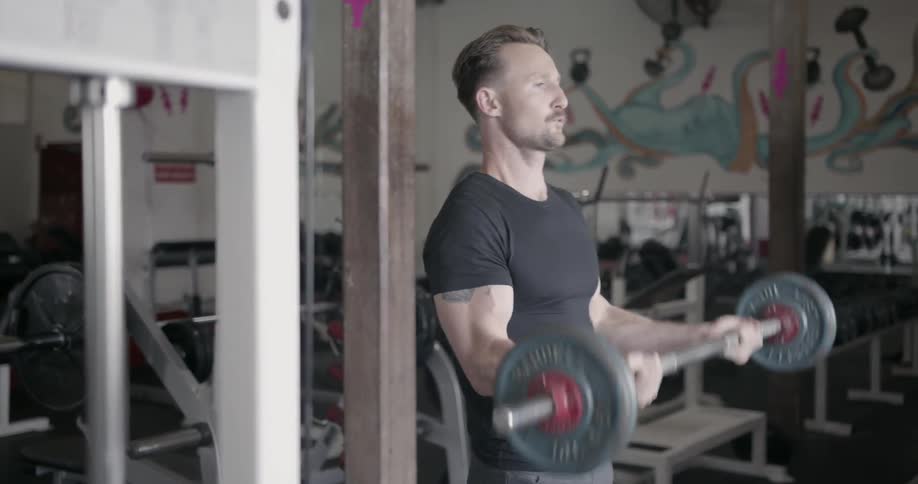 A man lifts weights in a gym