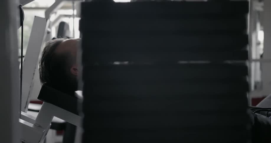 A man lifts weights in a gym