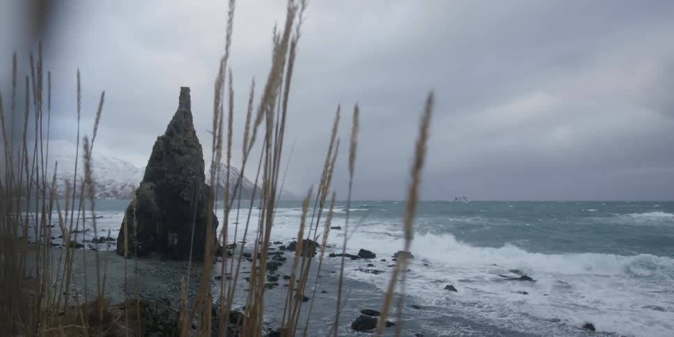 Waves are crashing against rocks on a stormy winter's day