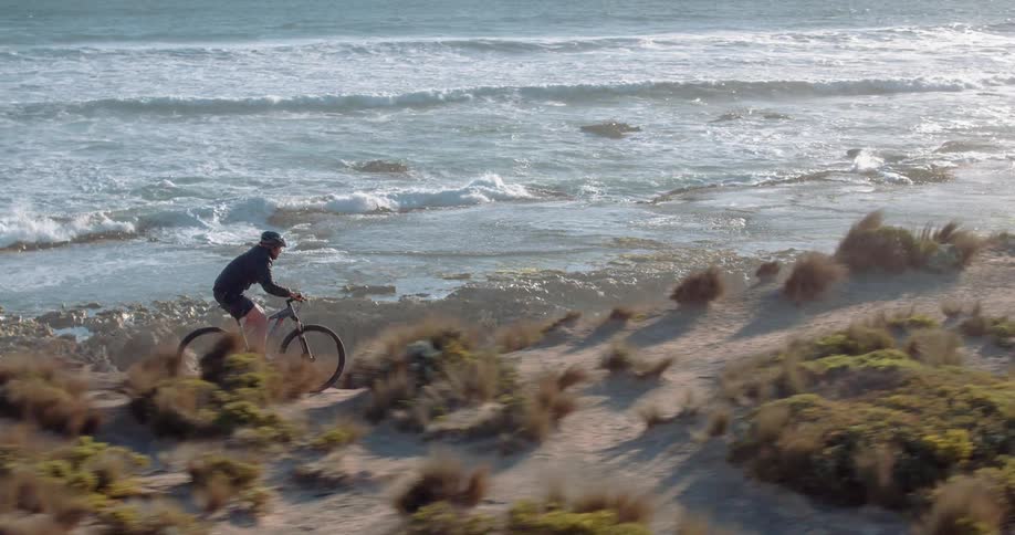 A bicyclist rides along an ocean coast