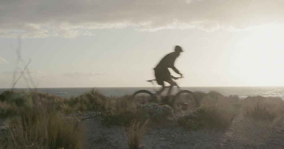 A bicyclist rides by the beach shore