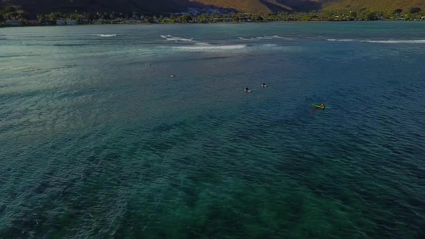 Surfers float out on the water waiting for waves