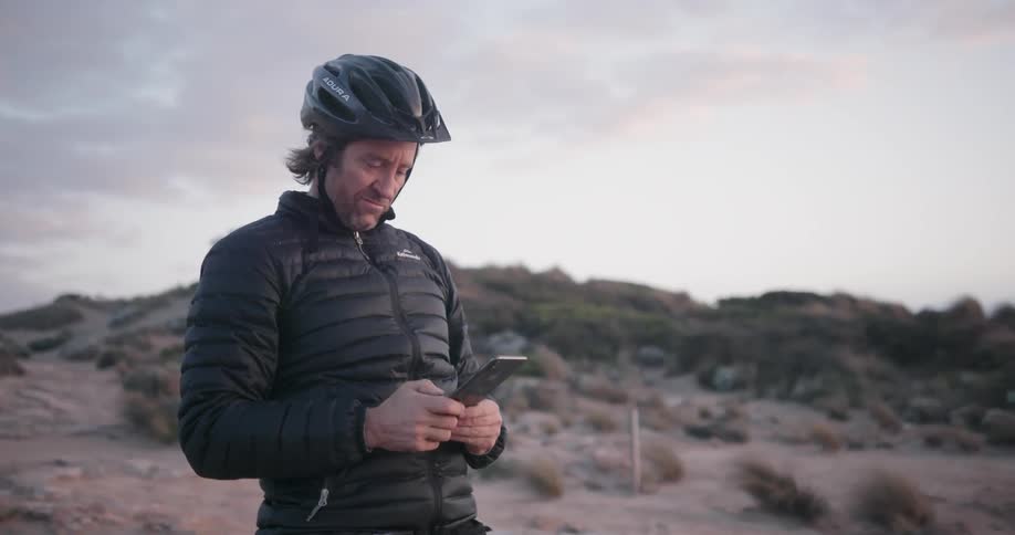 A bicyclist stops to take a photograph at sunset