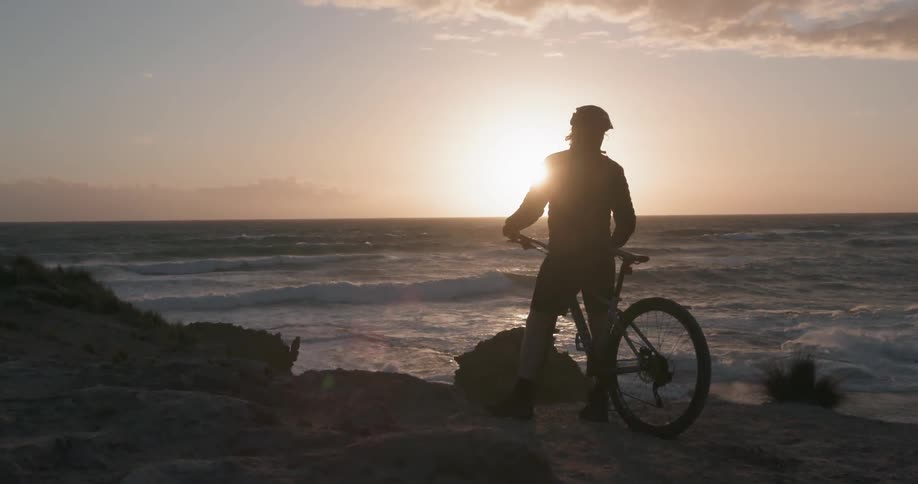 A man on a bike looks out at the ocean
