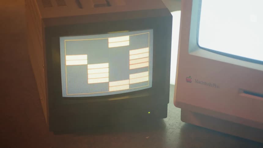 A pattern is moving on a monitor sitting next to a computer
