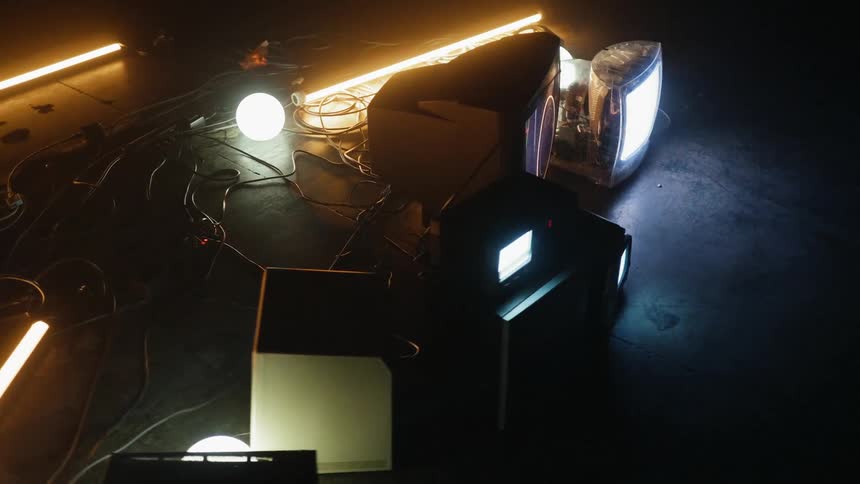 Tvs sit on the floor in a dark room