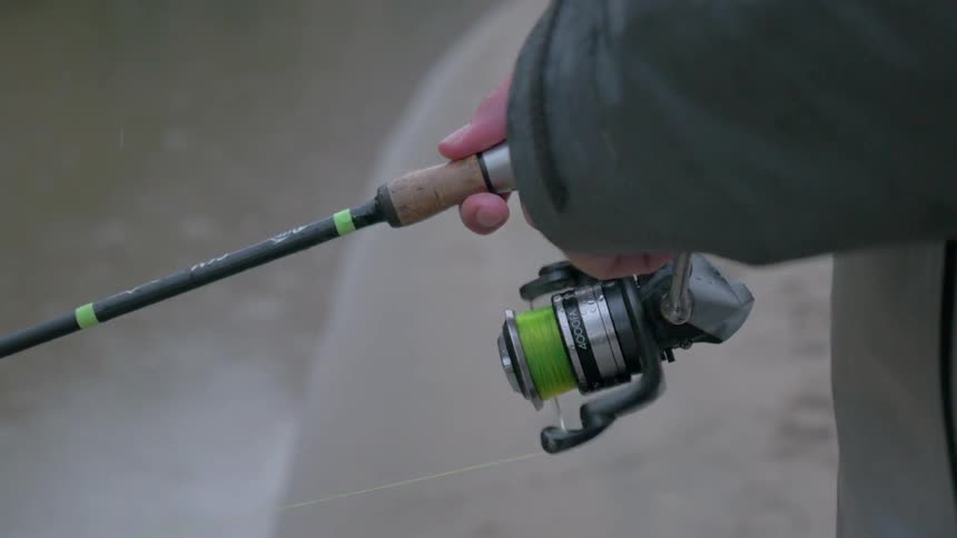 A person is reeling in the fishing line
