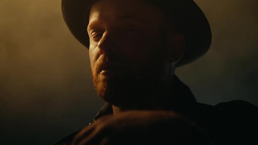 A man stands in a dark room with flashing lights