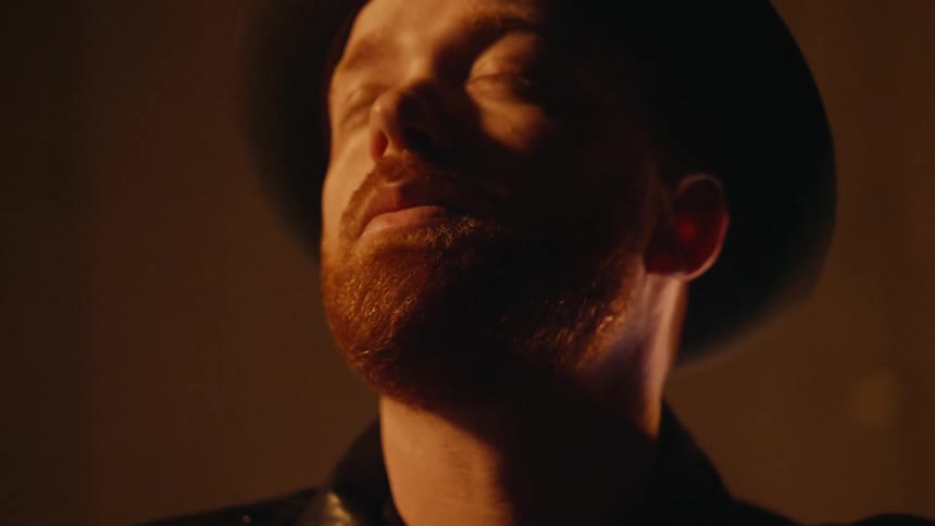 A man is looking up toward the ceiling and closing his eyes