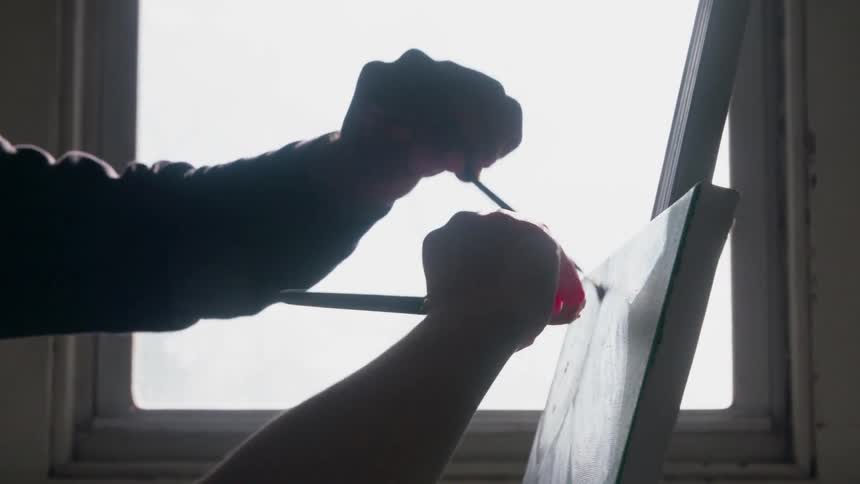Two people are painting a portrait