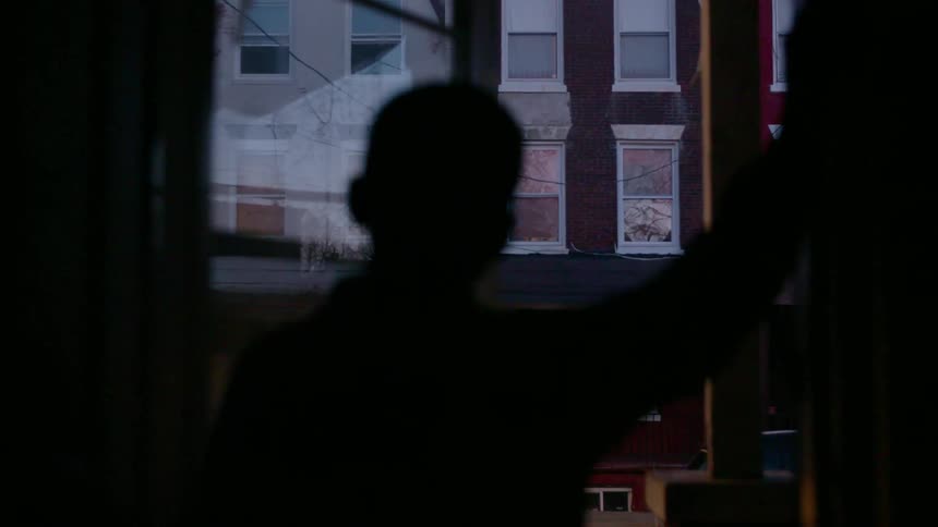 A kid is looking out of a window
