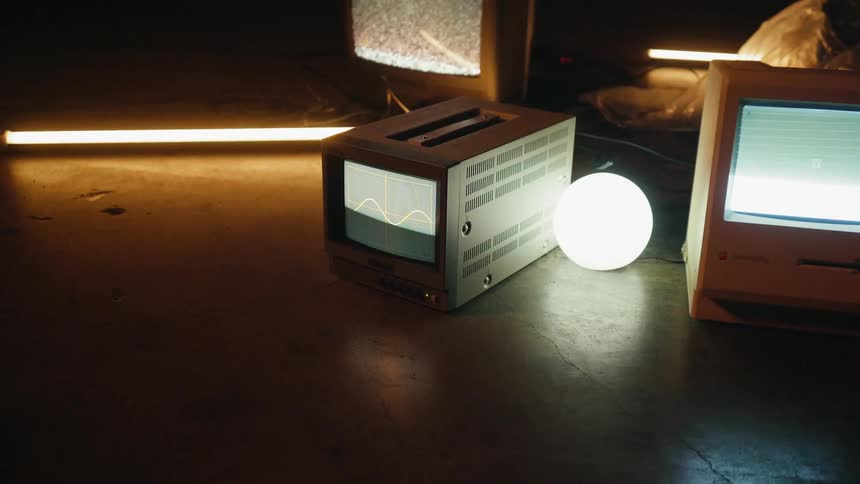 A person is walking away from a collection of monitors sitting on the ground