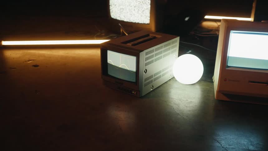 Monitor screens are showing patterns as they sit on the ground in a room