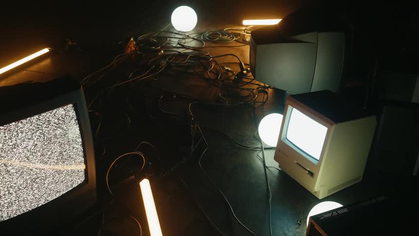 A pattern is flashing on a television sitting on the ground with other equipment