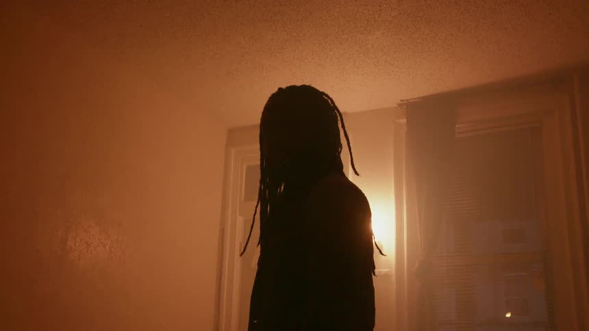 A man standing inside a room is turning away from a wall