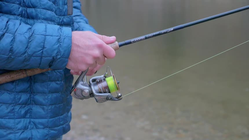 A person is using a fishing pole in the stream