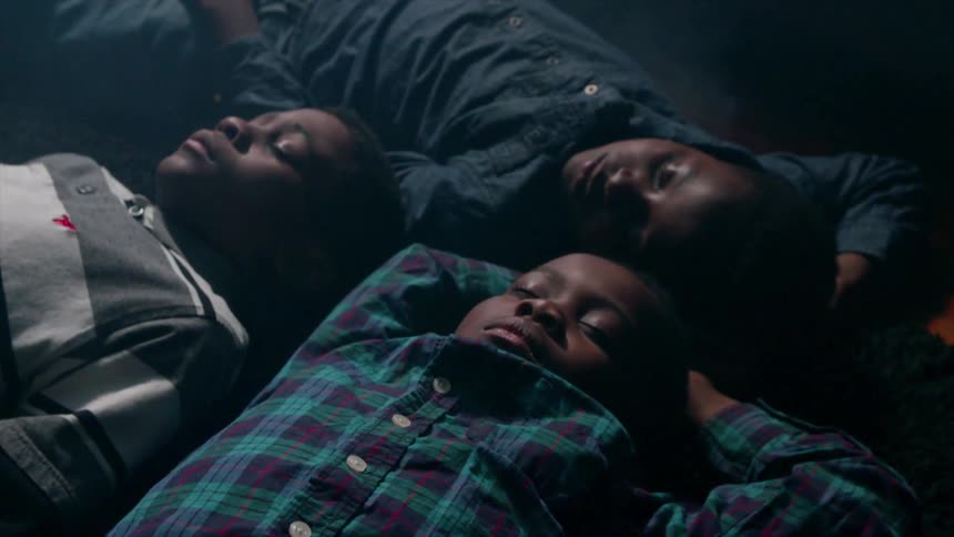 Three boys are sleeping on the ground