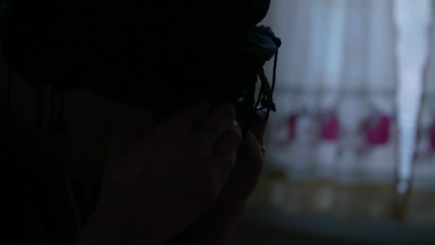 A woman shakes her head and leans into her hands