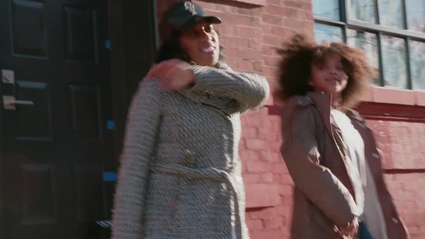 Two women dance on the sidewalk