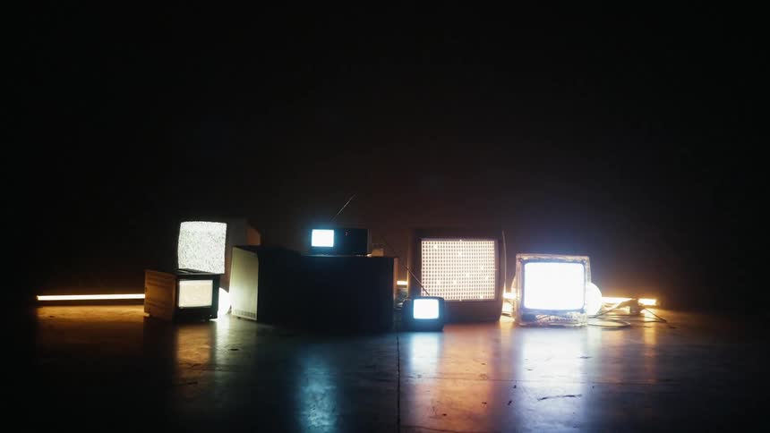 A pattern is flashing on a television sitting on the ground with other equipment