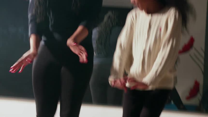 A teacher is rehearsing a dance with a girl in a schoolroom