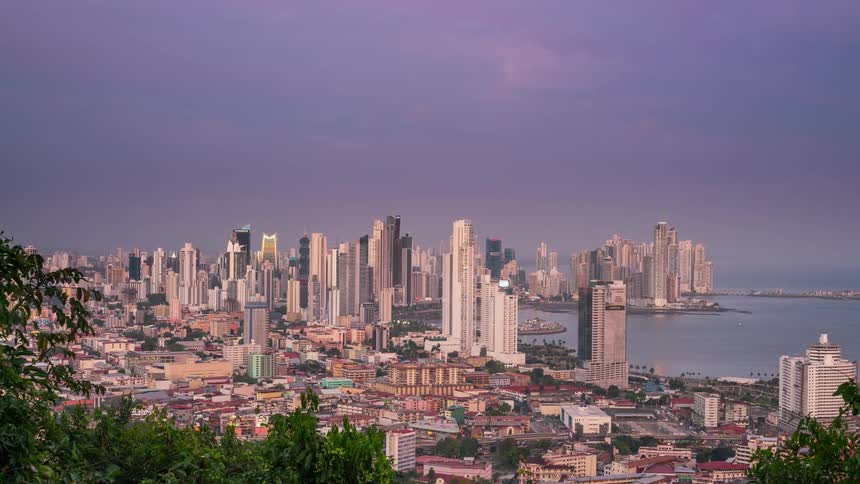 Clouds are floating over a city as day turns to dusk
