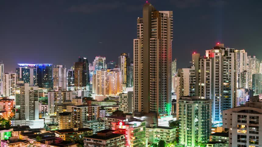 The buildings are tall and blinking with lights at night