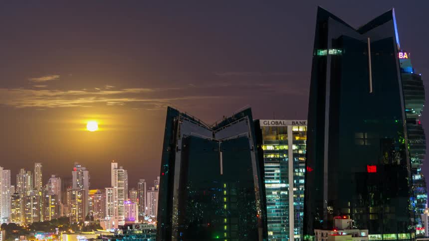 The sun is rising above the city ahead