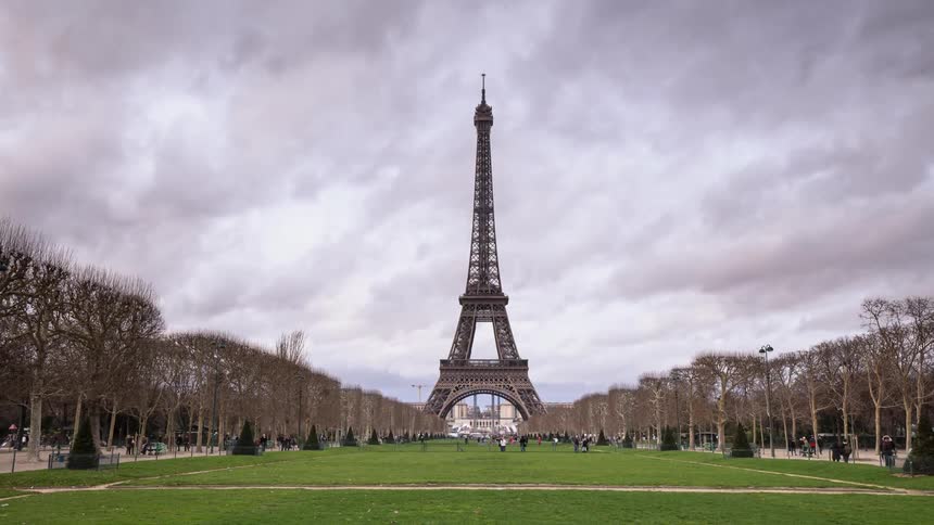 People walk around the tall tower ahead