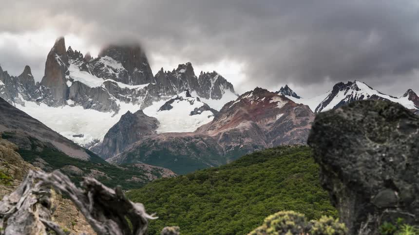 Clouds pass over a snow covered mountain peak