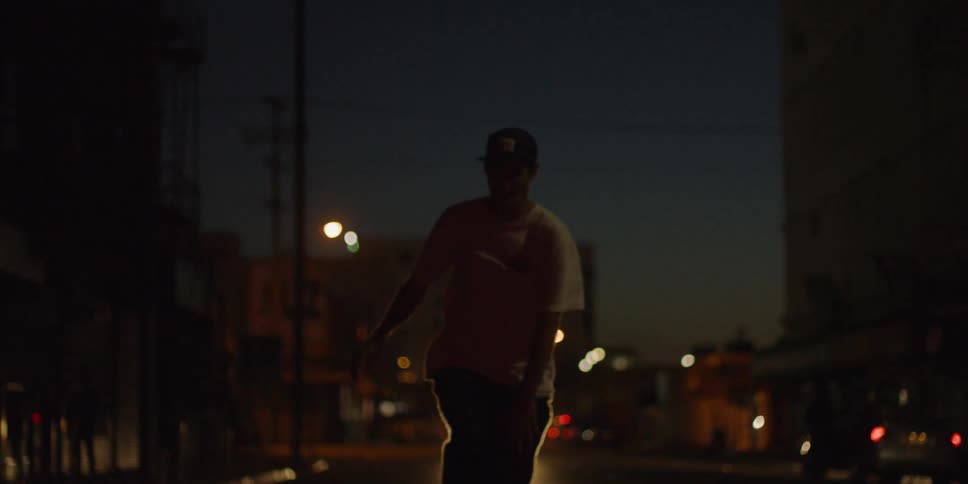 A man is riding his skateboard on the road at night