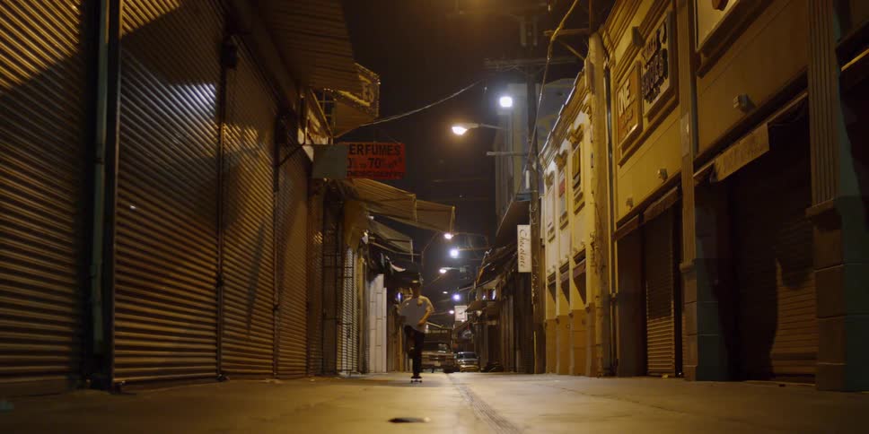 A man rides his skateboard fast down the alley