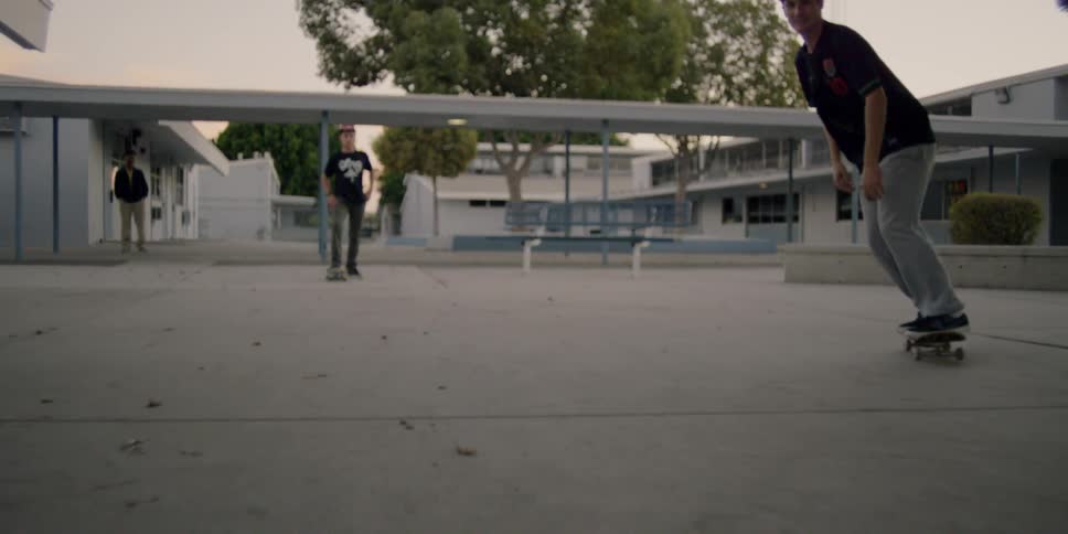 A man jumps his skateboard riding on a ledge in the lot