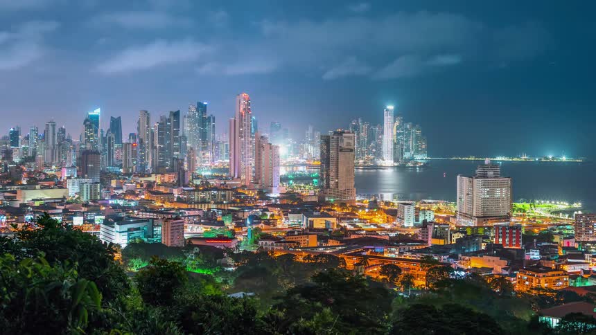 Lights from traffic and skyscrapers glow in a city skyline