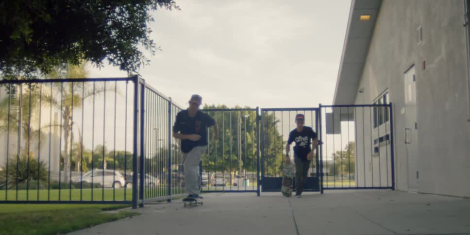 Two teenagers are skateboarding in a residential community during the day